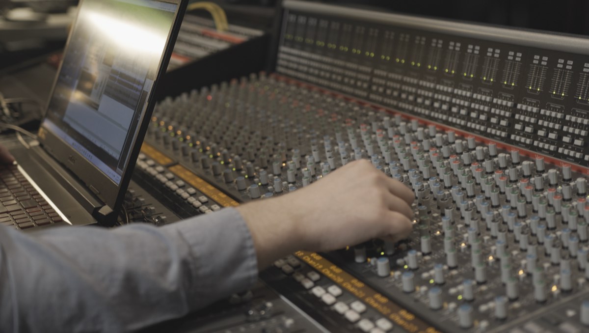 Engineer working at a mixing console in the studio